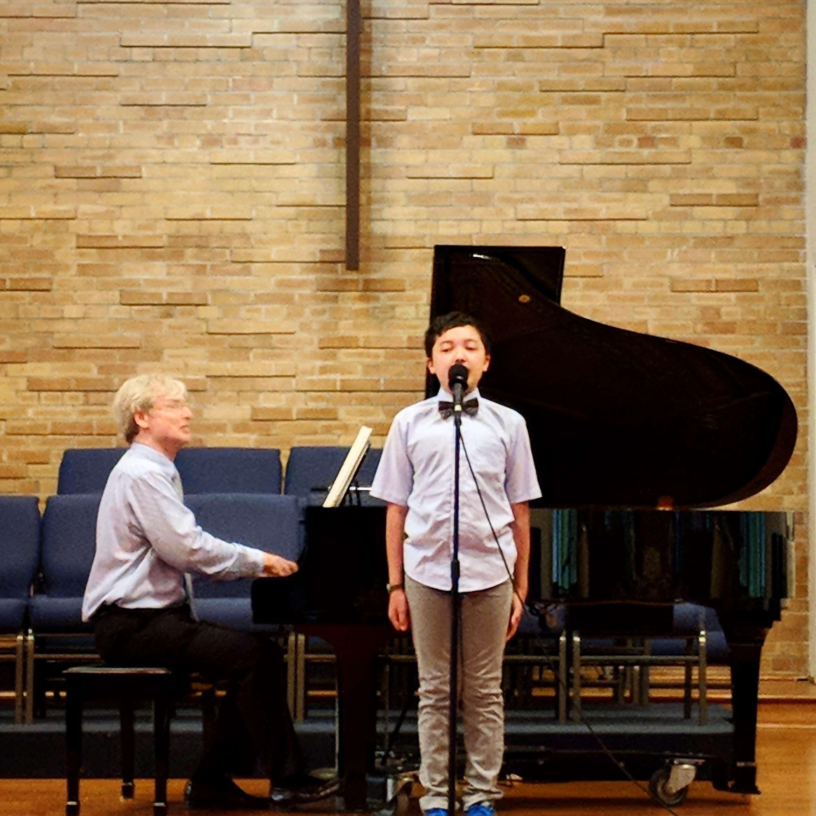 Student singing with a teacher accompanying on piano during a Musica Music School recital in Toronto